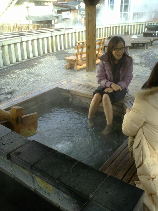 A tourist soaks her feet in an ashiyu (foot onsen), in the Kusatsu center.